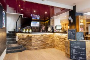 a restaurant with a counter and stairs in front of it at Hotel Le Dauphin in Honfleur