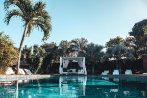 a wedding ceremony in the middle of a swimming pool with palm trees at Serena Buzios in Búzios
