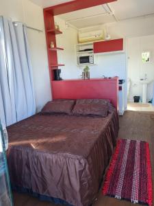 a bedroom with a large bed with a red headboard at Hindu Box Containers e Cabanas in Praia do Rosa