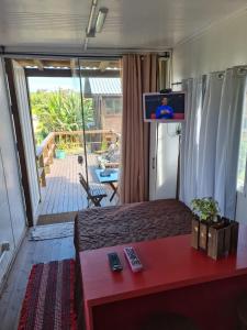 a bedroom with a bed with a tv on top of it at Hindu Box Containers e Cabanas in Praia do Rosa