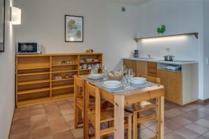 cocina con mesa con sillas y barra en Appartamenti San Carlo, en Costermano