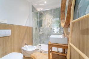 a bathroom with a toilet and a sink and a shower at Mensos Rooms in Olbia