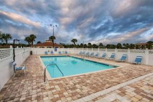a large swimming pool with chairs and a fence at St Augustine Ocean and Racquet 3102 in St. Augustine