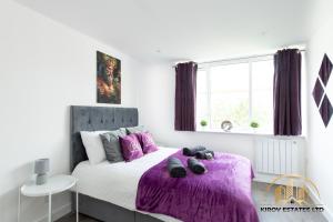 a bedroom with a bed with a purple blanket at Dionysus Apartment - The Celebration of Town in Southampton