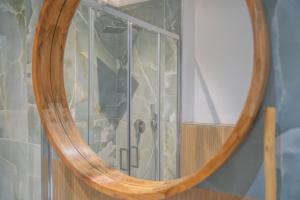 a mirror with a reflection of a shower in a room at Mensos Rooms in Olbia