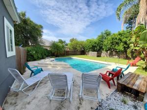 a backyard with a pool with chairs and a table at Floridays in Saint Augustine Beach
