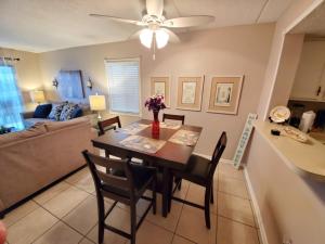a dining room and living room with a table and chairs at St Augustine Ocean and Racquet 3102 in Saint Augustine