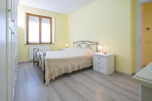 um quarto com uma cama, uma cómoda e uma janela em Casa Gli Ulivi em Montepulciano