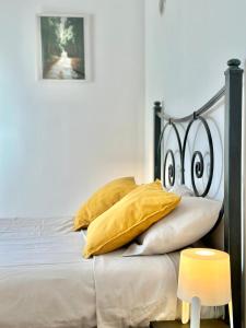 um quarto com uma cama preta e branca com almofadas amarelas em casa de praia em Charneca