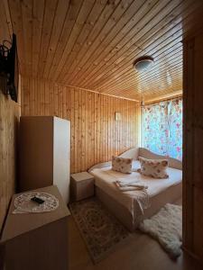a small room with a bed and a window at Pensiunea Valea Frumoasei in Şugag