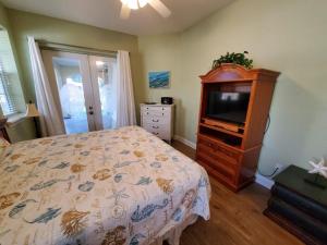 um quarto com uma cama, uma cómoda e uma televisão em Treasure Beach em Saint Augustine