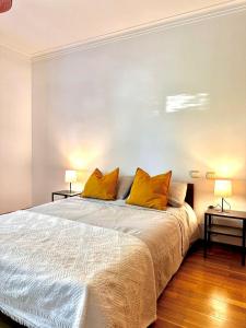 um quarto com uma cama grande e almofadas amarelas em casa de praia em Charneca