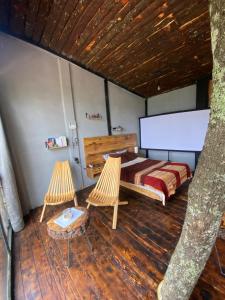 a bedroom with a bed and two chairs at Cabañas Everest in Mineral del Monte