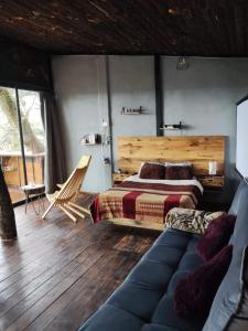 ein Schlafzimmer mit einem Bett und einem Sofa in einem Zimmer in der Unterkunft Cabañas Everest in Mineral del Monte