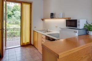 a kitchen with a sink and a microwave at Appartamenti San Carlo in Costermano