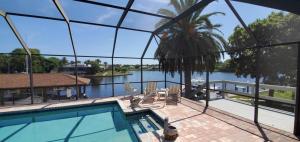 a house with a swimming pool and a view of the water at Getaway Canal in Palm Coast