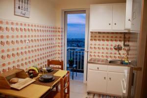 a kitchen with a table and a view of a balcony at Penthouse with Sea View in Athens