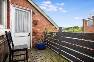 a wooden deck with a door and a chair at Terrace View Home in South Shields, Sleeps 7 in South Shields