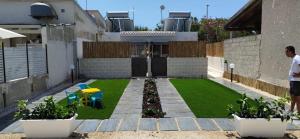 a backyard with a yard with grass and plants at Sabbia d'oro in Santa Maria Del Focallo