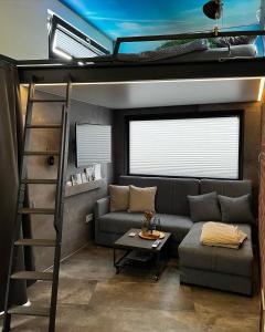 a living room with a couch and a loft bed at Sea Side Tiny House London in Salzhemmendorf