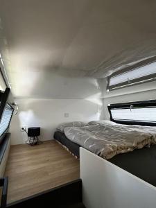 ein kleines Schlafzimmer mit einem Bett und einem Fenster in der Unterkunft Sea Side Tiny House London in Salzhemmendorf