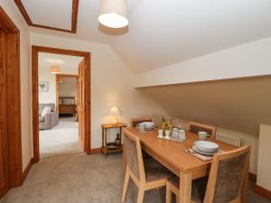 a dining room with a wooden table and chairs at Whitlow Lodge Annex in Gloucester