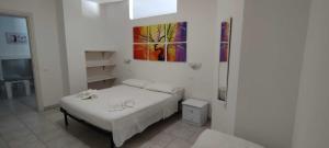 a bedroom with a bed and a painting on the wall at Salentum Villa Miami - con ampia terrazza in Vignacastrisi