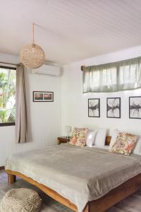 a bedroom with a large bed and a window at Ohana Villas in Santa Teresa Beach