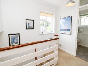 Un baño con paredes blancas y una escalera larga. en 1 Westwood Close, en Cowes 25 fotos más