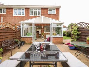 Un invernadero blanco con una mesa en un patio. en 1 Westwood Close, en Cowes