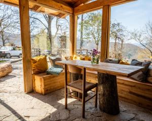 ビッビエーナにあるnovanta nature retreatの木製のポーチ(テーブル、ソファ付)