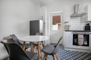 uma cozinha com uma mesa e cadeiras e um frigorífico em Spacious 3-Bed Home in South Shields, Sleeps 8 em South Shields