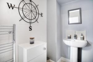 a bathroom with a sink and a wheel on the wall at Spacious 3-Bed Home in South Shields, Sleeps 8 in South Shields