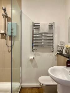 a bathroom with a shower and a toilet and a sink at The Churchill Court in Woodstock