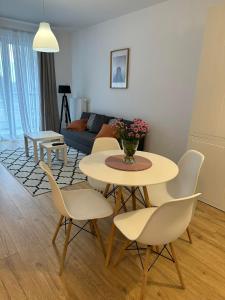 a living room with a table and chairs and a couch at Letnica41 by MYPART in your apartment in Gdańsk