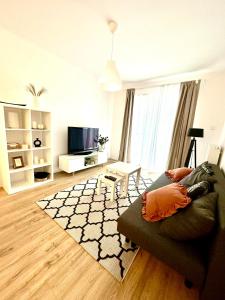 a living room with a couch and a tv at Letnica41 by MYPART in your apartment in Gdańsk