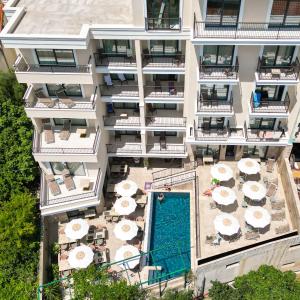 an aerial view of a building with a pool and umbrellas at Hotel Pima Budva in Budva