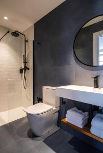 a bathroom with a toilet and a sink and a shower at Apartamentos El Reloj in Luanco