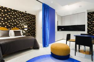 a bedroom with a bed and a desk and a kitchen at Apartamentos El Reloj in Luanco