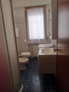een badkamer met een wastafel, een toilet en een raam bij Alloggio Maria in San Bartolomeo al Mare