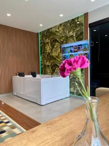un vaso con un fiore rosa seduto su un tavolo di 313 Villa Boutique Hotel City Center a Tirana