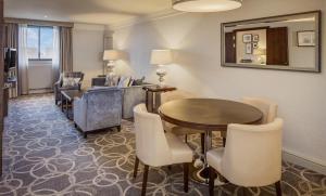 a living room with a table and chairs at Glasgow Grosvenor Hotel in Glasgow