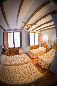 a bedroom with three beds and two windows at Hotel Hermanos Macias in Ronda