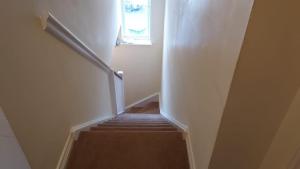 a stairway with a window and a stair case at Lovely 2 Bedroom Family Holiday Home in Thamesmead