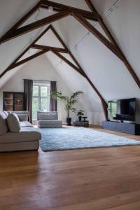 ein Wohnzimmer mit einem Sofa und einem TV in der Unterkunft Park Lofts Groningen Penthouse in Groningen