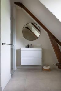 een witte badkamer met een wastafel en een spiegel bij Park Lofts Groningen Penthouse in Groningen