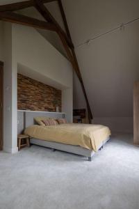 ein Schlafzimmer mit einem Bett und einer Ziegelwand in der Unterkunft Park Lofts Groningen Penthouse in Groningen