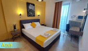 a bedroom with a large bed with yellow walls at Ionis Studios in Lefkada