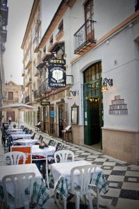 una fila de mesas y sillas en una calle de la ciudad en Hotel Hermanos Macias, en Ronda
