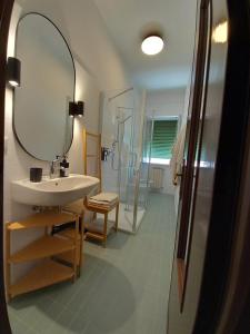 La salle de bains est pourvue d'un lavabo, d'un miroir et d'une douche. dans l'établissement Home Poetry_La Spezia_Cinque Terre, à La Spezia